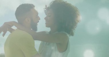 Çift ırklı çiftlerin kucaklaşması üzerine ışık noktalarının canlandırılması. Yaşam tarzı ve doğa konsepti dijital olarak oluşturulmuş video.