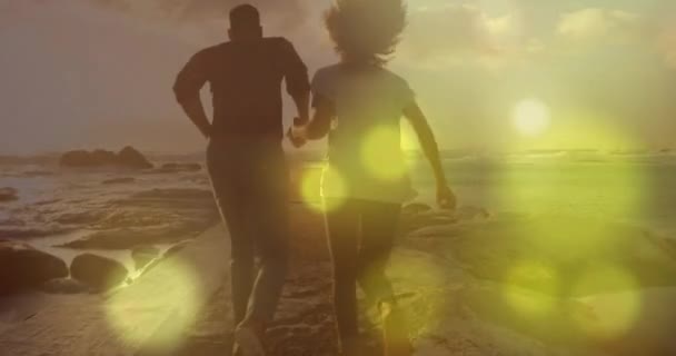 ビーチで走っているカップルに光スポットのアニメーション ライフスタイルと自然コンセプトデジタル生成ビデオ — ストック動画
