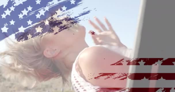 夏のビーチで車で幸せな白人女性の上にアメリカの国旗のアニメーション アメリカの愛国心 多様性 休暇の概念がデジタル生成されたビデオ — ストック動画
