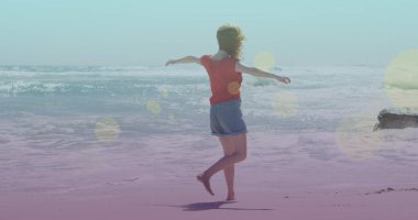 Kumsalda yürüyen beyaz bir kadının üzerindeki ışık lekeleri. yürüyüş günü ve dijital olarak oluşturulan görüntü konsepti.