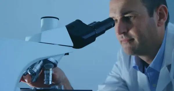 Cientista Caucasiano Examina Amostras Num Microscópio Num Laboratório Seu Foco — Fotografia de Stock