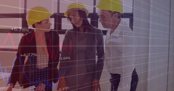 Image of multiple graphs over diverse engineers wearing helmets discussing blue print in office. Digital composite, multiple exposure, report, business, safety, communication and teamwork concept.