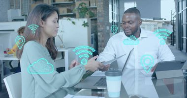 Ofis toplantısındaki çeşitli kadın ve erkek meslektaşlar üzerinde dijital iletişim simgeleri. Günlük iş, veri, dijital arayüz, bağlantı, ofis ve dijital olarak oluşturulan iletişim.