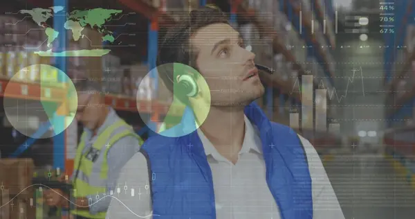 Digital composite of Caucasian male worker wearing headset while holding clipboard and checking inventory and colleague works behind him. Statistical data move in the foreground.