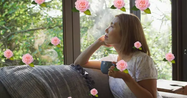 Wizerunek Różowych Róż Nad Uśmiechniętą Azjatką Pijącą Kawę Wyglądającą Przez — Zdjęcie stockowe
