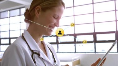 Tablet kullanan beyaz kadın doktor üzerindeki ikonlarla bağlantı ağının animasyonu. Dijital olarak oluşturulmuş küresel bağlantılar, tıp, iletişim ve dijital arayüz kavramı.