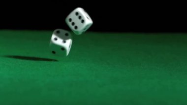 Siyah arka plandaki yeşil masada düşen zarların canlandırması. Soyut arkaplan ve dijital olarak oluşturulan video konseptini şekillendirir.
