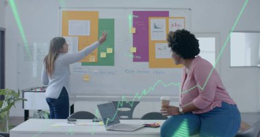 Çeşitli kadın meslektaşların ofis toplantılarında beyin fırtınası yapmaları için yeşil çizelge ve oklar. Günlük iş, veri, dijital arayüz, takım çalışması, ofis ve dijital olarak oluşturulan iletişim.