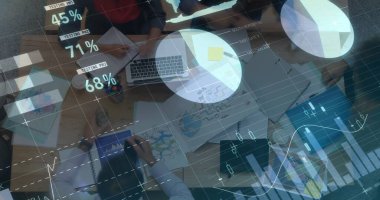 Çeşitli takımlar dizüstü bilgisayardaki ve belgelerdeki verileri analiz eder. Şeffaf dijital grafikler sahneyi kaplıyor. Teknoloji odaklı bir iş analizi öneriyor..