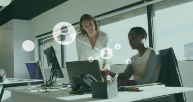 Dizüstü bilgisayardaki raporları tartışan çeşitli kadın çalışanlar üzerinde bağlantılı simgelerin görüntüsü. Dijital bileşik, çoklu pozlama, iletişim, planlama, iş, takım çalışması ve teknoloji kavramı.