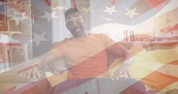 Kuva Yhdysvaltain Lippu Yli Onnellinen Afrikkalainen Amerikkalainen Mies Istuu Sohvalla — kuvapankkivalokuva