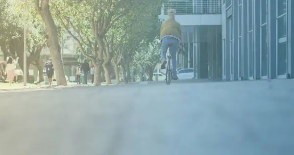 在街上骑着自行车的男子的后视镜上的亮点 — 图库照片