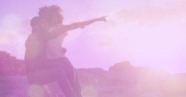 Sahilde birbirleriyle konuşan Afrikalı Amerikalı çiftlere karşı bir ışık lekesi. Aşk ve ilişki kavramı