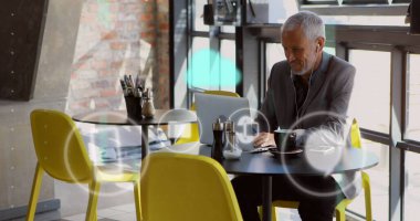 Kafkasyalı iş adamının dizüstü bilgisayarla işlediği simgeler ve veri işleme resimleri. Küresel iş, finans, hesaplama ve veri işleme kavramı dijital olarak oluşturulmuş görüntü.