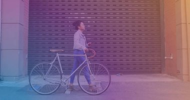 Spots of light against asian woman using smartphone while walking with her bicycle on the street. pedal day awareness concept