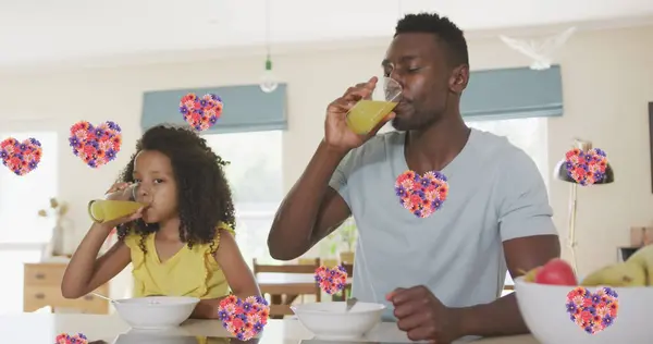 Obraz Serca Kwiatu Nad Afrykańskim Amerykańskim Ojcem Córką Pijących Sok — Zdjęcie stockowe