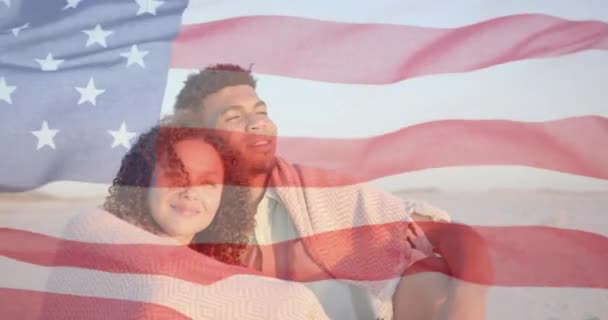 Animación Bandera Americana Sobre Feliz Pareja Diversa Sentada Playa Soleada — Vídeo de stock