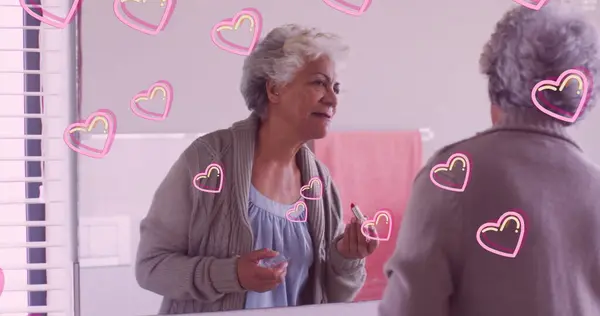 Obraz Różowych Serc Nad Szczęśliwą Białą Starszą Kobietą Nakładającą Szminkę — Zdjęcie stockowe