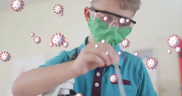 Multiple covid-19 cells floating against boy wearing face mask performing experiment in laboratory. covid-19 coronavirus pandemic concept