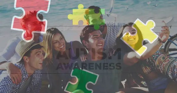 Image of colourful puzzle pieces and autism text over happy friends at summer beach party. autism, learning difficulties, support and awareness concept digitally generated image.