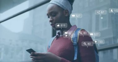 Akıllı telefon kullanan Afrikalı Amerikalı bir kadının medya simgelerinin canlandırılması. Sosyal medya, yaşam tarzı ve dijital arayüz konsepti dijital olarak oluşturulmuş video.