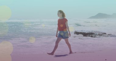 Kumsalda yürüyen beyaz bir kadının üzerindeki ışık lekeleri. yürüyüş günü ve dijital olarak oluşturulan görüntü konsepti.