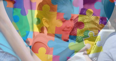 Tablet kullanan çeşitli okul çocuklarının bulmaca parçaları. otizm farkındalık ayı ve dijital olarak üretilen görüntü konsepti.