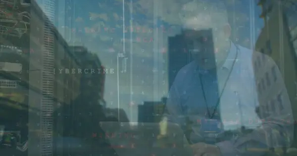 Caucasian man in a shirt is overlaid with digital cybersecurity terms. Reflections hint at a modern office setting, emphasizing the relevance of cyber security in business.