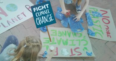 Değişik çocukların ekoloji protesto pankartları yapmaları üzerine iklim değişikliğiyle mücadele pankartı. İklim değişikliği, ekoloji, protesto ve çevre bilinci, dijital olarak üretilen video.