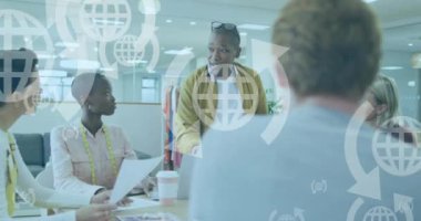 Ofisteki çeşitli iş adamları üzerinde çalışan dünya simgelerinin ve veri işlemlerinin animasyonu. Küresel finans, işletme, bağlantılar, hesaplama ve veri işleme kavramı, dijital olarak oluşturulmuş video.