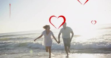 Yazın kumsalda el ele koşan çeşitli aşıklar üzerine kırmızı kalplerin animasyonu. Aşk, romantizm, sevgililer günü ve tatil konsepti, dijital olarak oluşturulmuş video.