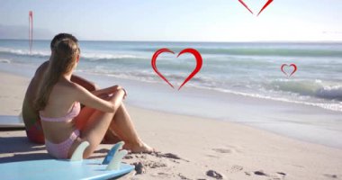 Yazın kumsalda birbirini seven farklı çiftler için kırmızı kalplerin animasyonu. Aşk, romantizm, sevgililer günü ve tatil konsepti, dijital olarak oluşturulmuş video.