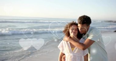 Yazın kumsalda birbirini seven farklı çiftlerin üzerinde hareket eden kalplerin animasyonu. Aşk, romantizm, sevgililer günü ve tatil konsepti, dijital olarak oluşturulmuş video.