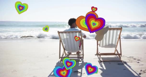 夏のビーチでデッキチェアに恋する多様なカップルに心を動かすアニメーション ロマンス バレンタインの日と休暇の概念 デジタル生成されたビデオ — ストック動画