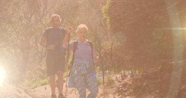 Kırsalda yürüyüş yapan beyaz bir çift. Lens ve Bokeh City ışıkları üzerinde. aktif, sağlıklı emeklilik konsepti, dijital olarak oluşturulmuş görüntü.