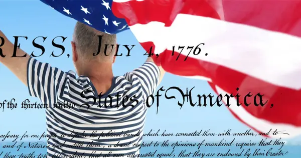 アメリカ合衆国の書かれた憲法のデジタル画像が画面に映し出され 背景にはアメリカ国旗を掲げる白人男性が映っている — ストック写真