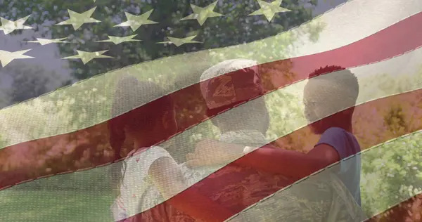 Изображение Мужчины Солдата Обнимающего Улыбающихся Дочь Сына Над Американским Флагом Лицензионные Стоковые Изображения