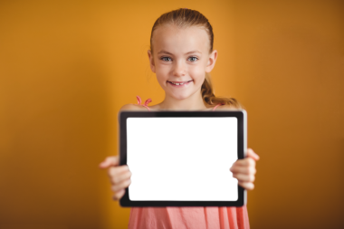 Beyaz kızın elinde tablet tutarken çekilmiş dijital png fotoğrafı ve şeffaf bir arka planı var. İzole fotoğraf, çocukluk ve iletişim konsepti.