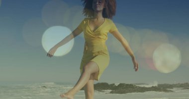 Sahilde yürürken kolları açık gezen melez genç bir kadının üzerindeki lenslerin yansıması. Dijital bileşik, kaygısız, neşeli, tatiller, deniz, yaz, doğa ve keyif kavramı.