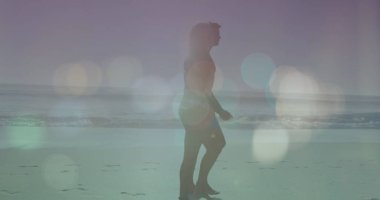 Güneşli bir günde plajda yürüyen beyaz tenli siluet üzerindeki merceklerin yansıması. Dijital bileşim, aşk, birliktelik, deniz, tatiller, aydınlanma, doğa ve keyif kavramı.