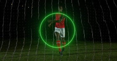 Afro-Amerikan erkek futbolcu üzerinde dönen neon geometrik şekiller. Spor, rekabet ve hareket kavramı dijital olarak oluşturulmuş imaj.