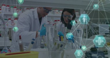 Beyaz erkek ve kadın meslektaşlar laboratuarda örnekler inceliyor. İkisi de laboratuvar önlüğü ve eldiven giyip araştırmalarına konsantre oluyorlar.