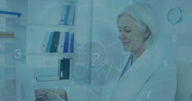 Hastanede dizüstü bilgisayar kullanan Kafkasyalı kıdemli kadın doktorun veri işleme görüntüsü. Tıbbi sağlık ve iş teknolojisi kavramı