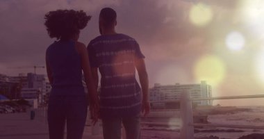 Plajdaki çift ırklı çiftin üzerindeki ışık lekeleri. Tatiller ve dijital arayüz konsepti dijital olarak oluşturuldu.