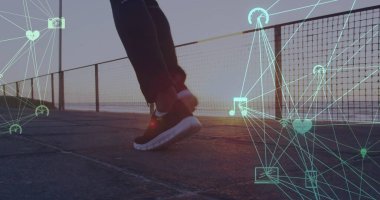Plajda koşan kişinin alçak kesiminde bağlı ikon kürelerinin görüntüsü. Dijital bileşik, çoklu pozlama, iletişim, küreselleşme, sağlık ve zindelik kavramı.