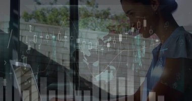 Mavi tişört giyen beyaz bir profesyonel cam üzerindeki dijital verileri inceliyor. Koyu renk saçları var. Parlak çizelge ve grafiklere odaklanmış.