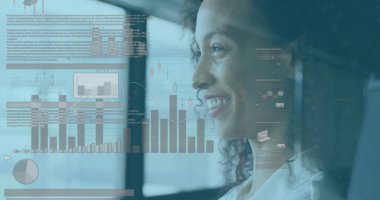 Ekranda dijital grafikleri inceleyen melez genç bir profesyonel. Sportif kıvırcık saçlı, açık kahverengi tenli, beyaz bluz giyen.