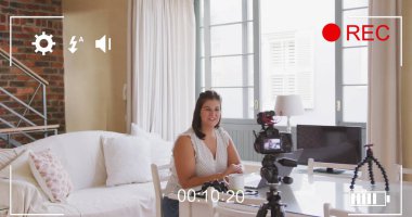 Evde video blogu kaydeden kadın vlogger üzerinde dijital arayüzlü kamera görüntüsü. küresel sosyal medya, bağlantı ve iletişim konsepti dijital olarak oluşturulmuş görüntü.