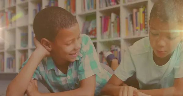 stock image Image of light trails over biracial boys reading books. children's book day and celebration concept digitally generated image.