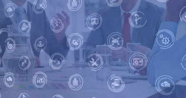 Çeşitli iş adamlarının toplantılarının ortasındaki simgelerin görüntüsü. İş, işbirliği ve teknoloji konsepti dijital olarak oluşturuldu.